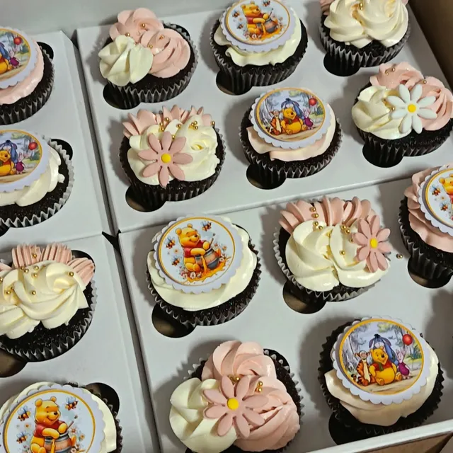 Boxed chocolate cupcakes with blush and ivory swirls, daisies, and printed toppers